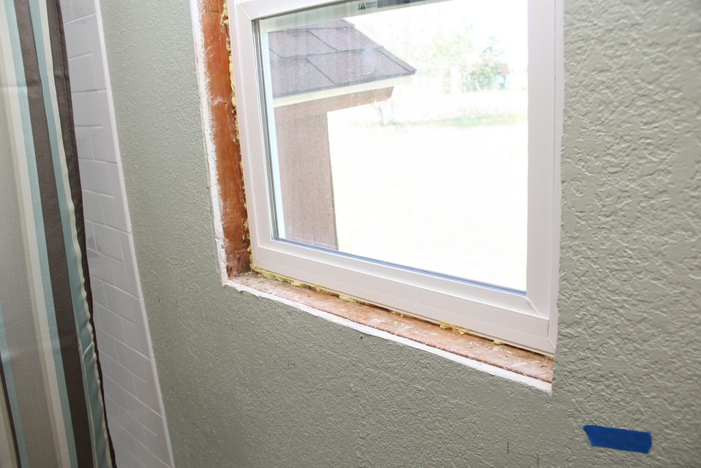 A newly fitted white window frame set into a freshly prepared wall opening